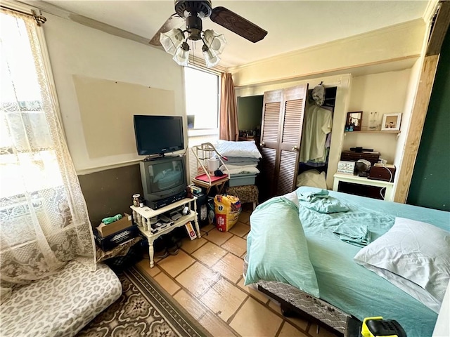 bedroom featuring a closet, ceiling fan, and crown molding