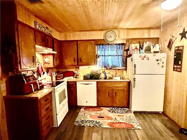 kitchen with sink, dark hardwood / wood-style flooring, white appliances, wooden walls, and wood ceiling