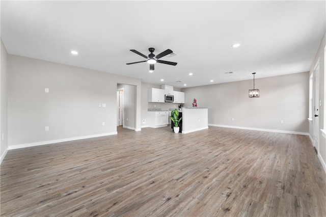 unfurnished living room with recessed lighting, baseboards, light wood-type flooring, and a ceiling fan