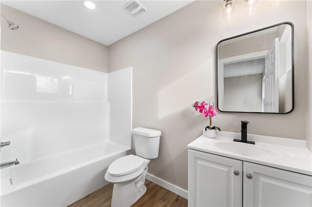 bathroom with visible vents, toilet, wood finished floors,  shower combination, and vanity