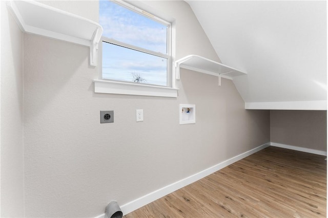 clothes washing area featuring baseboards, washer hookup, laundry area, wood finished floors, and electric dryer hookup