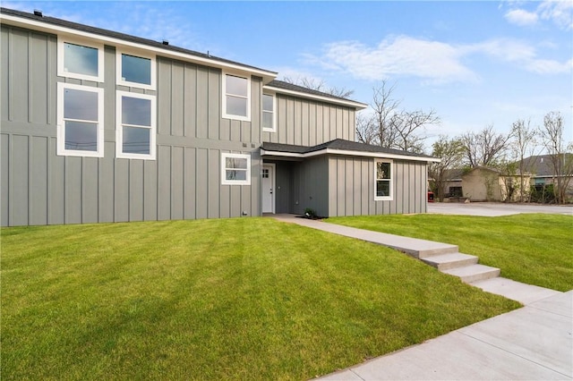 back of house with a lawn and board and batten siding