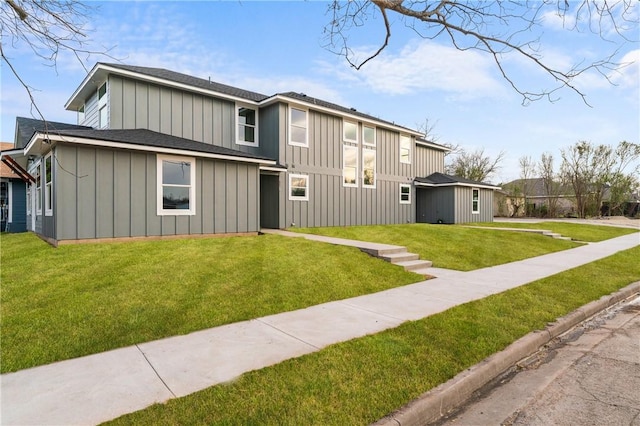 view of front of home with roof with shingles, board and batten siding, and a front yard