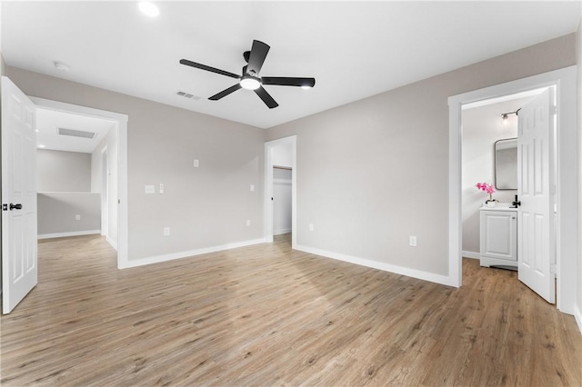 unfurnished bedroom featuring visible vents, baseboards, ensuite bath, and light wood-style flooring