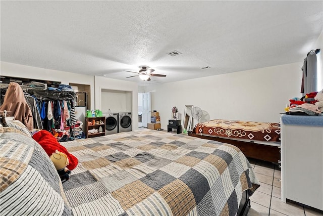 bedroom with independent washer and dryer, a textured ceiling, light tile patterned floors, and ceiling fan