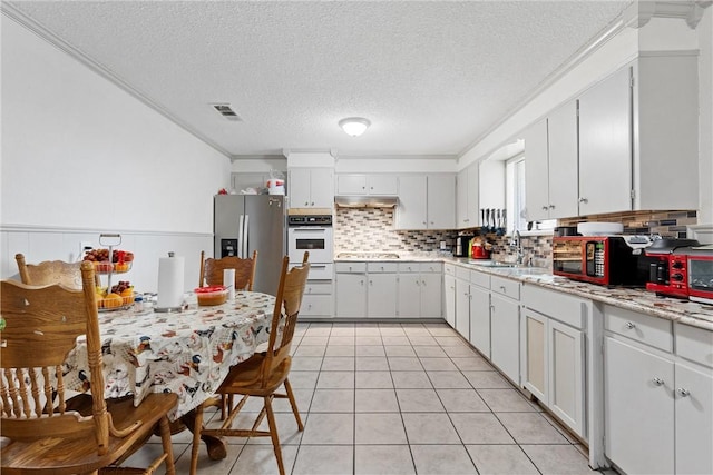 kitchen with sink, white oven, stainless steel fridge with ice dispenser, white cabinets, and ornamental molding