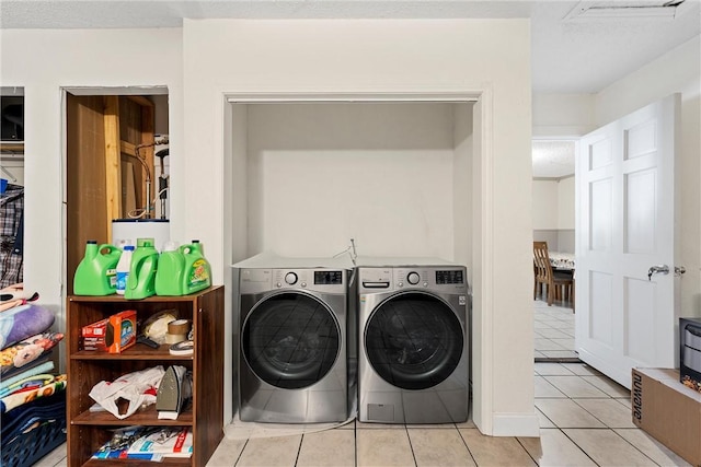 laundry room featuring light tile patterned floors and washing machine and clothes dryer