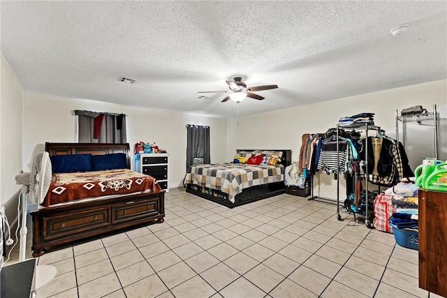 tiled bedroom with ceiling fan and a textured ceiling