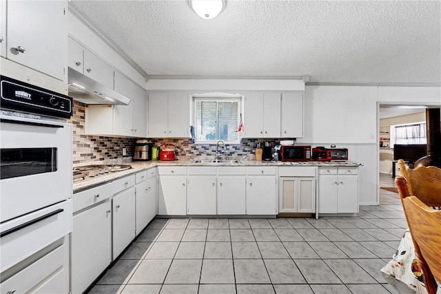 kitchen with white cabinets, sink, a textured ceiling, light tile patterned flooring, and stainless steel gas cooktop