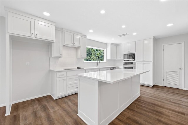 kitchen featuring a center island, dark hardwood / wood-style floors, white cabinetry, and black appliances