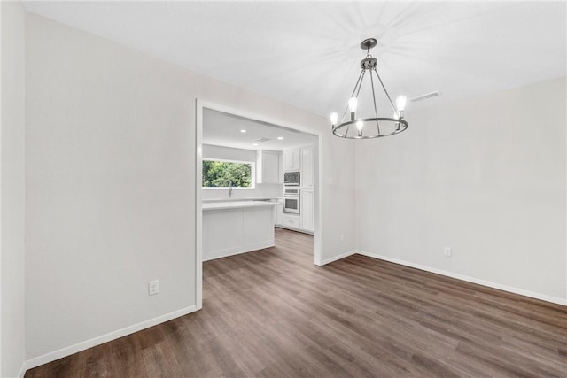 unfurnished dining area with dark hardwood / wood-style floors and an inviting chandelier