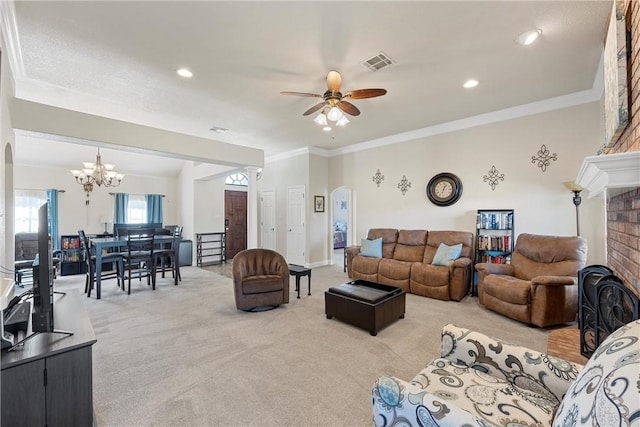 living room with ceiling fan with notable chandelier, light colored carpet, crown molding, and a brick fireplace