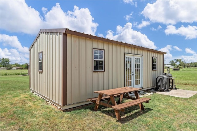 view of outbuilding with a lawn and french doors