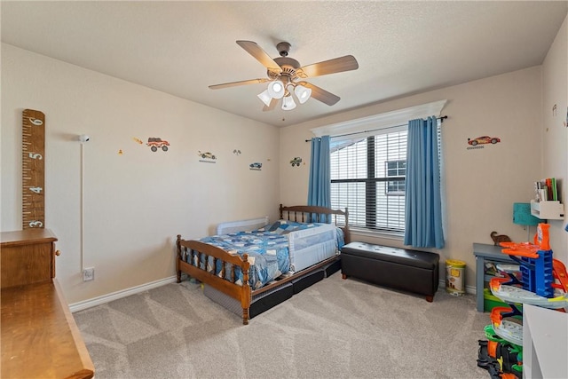 carpeted bedroom with ceiling fan and a textured ceiling