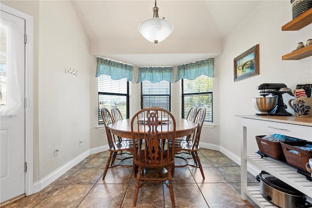 dining area with tile patterned flooring and vaulted ceiling