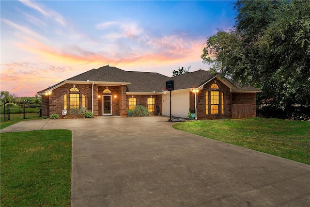 ranch-style home with a yard and a garage