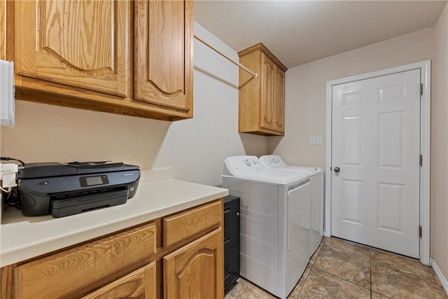 clothes washing area featuring cabinets, independent washer and dryer, a textured ceiling, and light tile patterned floors