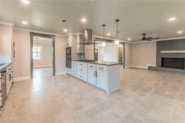 kitchen with wall chimney exhaust hood, ceiling fan, a fireplace, decorative light fixtures, and white cabinetry