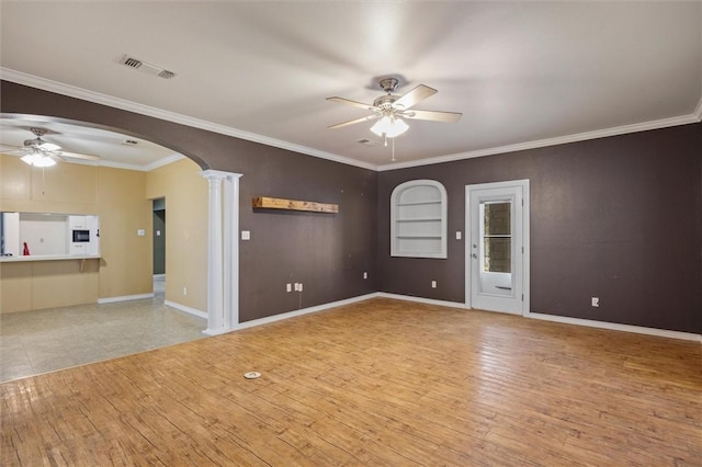 unfurnished room with built in shelves, light hardwood / wood-style flooring, ceiling fan, and ornate columns