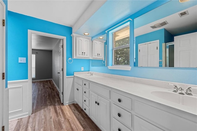 bathroom with hardwood / wood-style flooring, vanity, and a shower with shower door