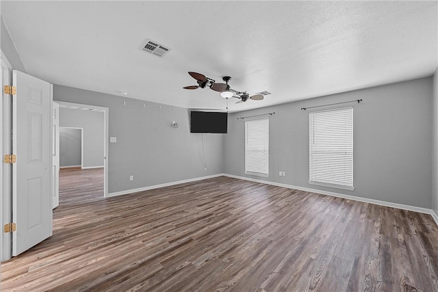 empty room featuring a textured ceiling, hardwood / wood-style flooring, and ceiling fan