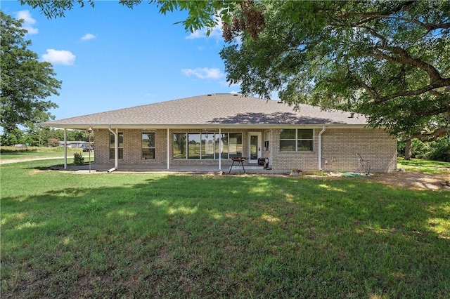 rear view of property featuring a patio and a lawn