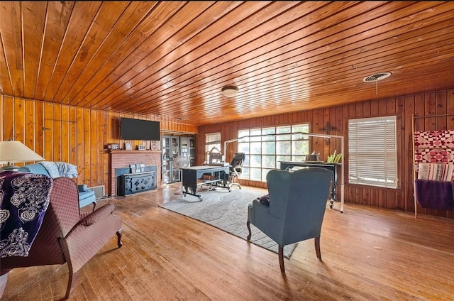 living room featuring light wood-type flooring and wooden ceiling