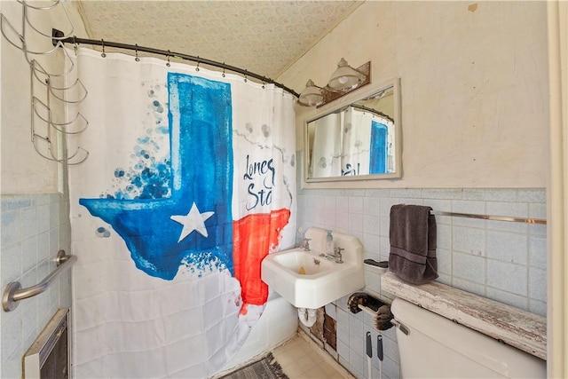 bathroom with tile walls and toilet