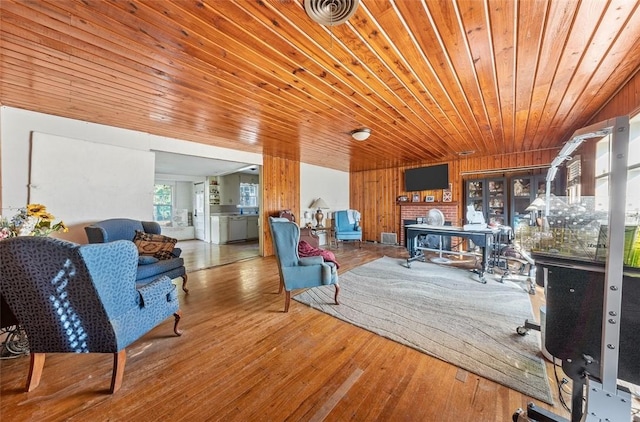 living room with hardwood / wood-style flooring, wooden walls, and wood ceiling