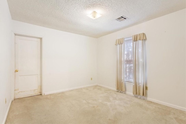 carpeted spare room featuring a textured ceiling