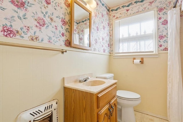 bathroom with vanity, tile walls, and toilet