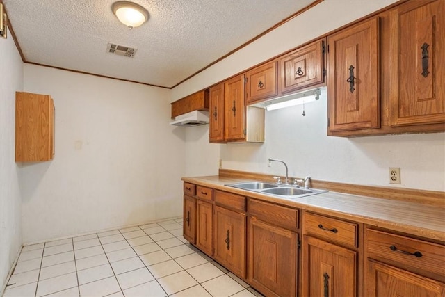 kitchen with a textured ceiling, light tile patterned flooring, and sink