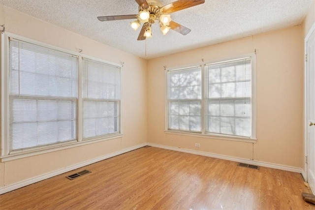 spare room with ceiling fan, a textured ceiling, and light wood-type flooring