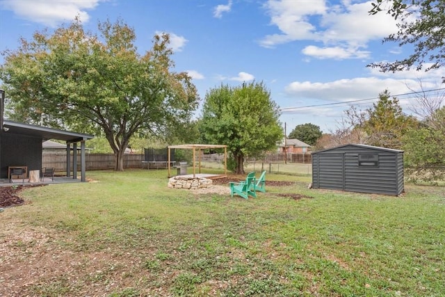 view of yard with a trampoline and a storage unit