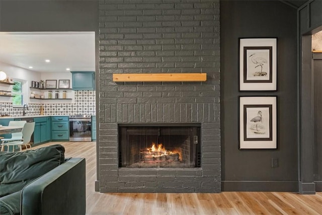 details with a fireplace, hardwood / wood-style floors, stainless steel range with electric cooktop, and sink