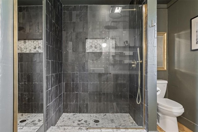 bathroom with toilet and a tile shower