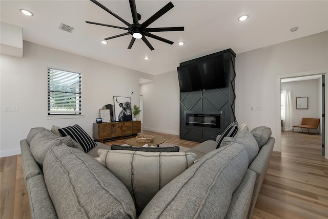 living room with ceiling fan and light hardwood / wood-style floors