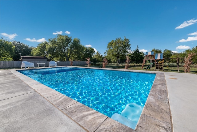 view of pool with a playground and a patio