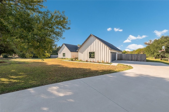 view of front facade featuring a garage, an outbuilding, and a front lawn