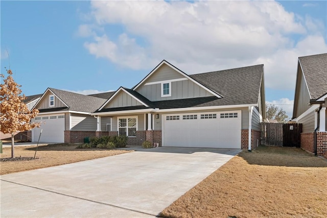 craftsman-style home featuring brick siding, a shingled roof, fence, concrete driveway, and board and batten siding