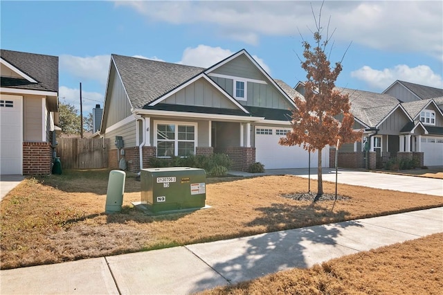 craftsman-style house with board and batten siding, brick siding, driveway, and fence