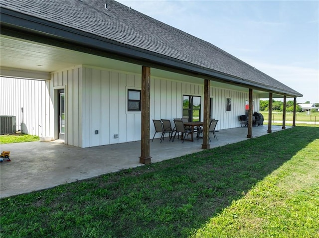 rear view of house featuring central AC, a lawn, and a patio