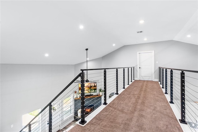 hallway with vaulted ceiling and carpet