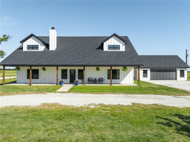 view of front of home with a front yard, a porch, and a garage