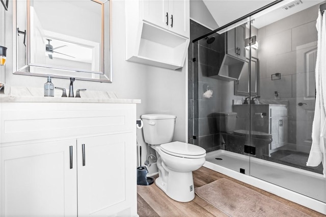 bathroom with toilet, vanity, lofted ceiling, hardwood / wood-style floors, and an enclosed shower