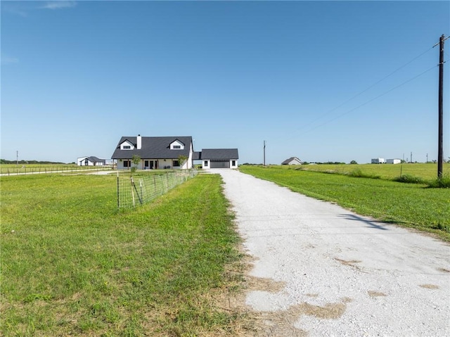 view of front of home with a front lawn and a rural view