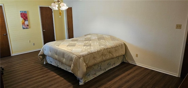 bedroom with dark hardwood / wood-style flooring and a chandelier