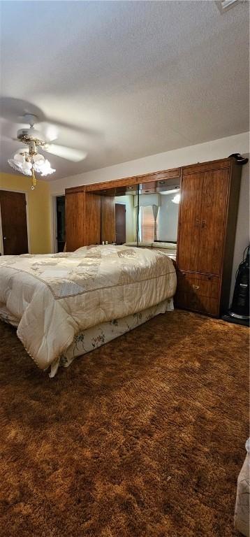 bedroom featuring carpet, ceiling fan, and a textured ceiling