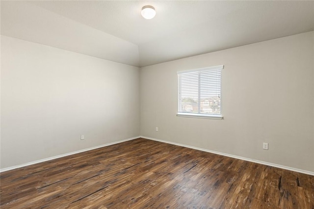 unfurnished room with lofted ceiling and dark wood-type flooring