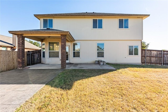 back of house featuring a patio area and a yard